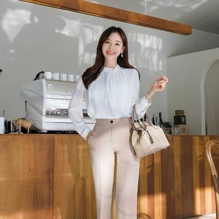 Chiếc áo sơ mi cổ đính ngọc mềm mại, giúp outfit với quần tây thêm trẻ trung, hiện đại